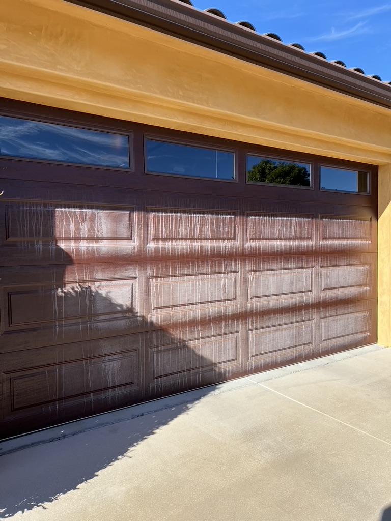 Oxidized garage door surface. Only water was used to rinse it down while cleaning the windows.